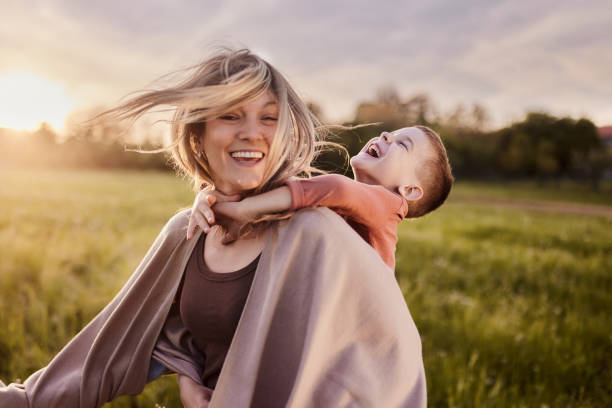 istock Cheerful mother having fun with her son in nature at sunset. 2148666170