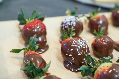 Strawberry dessert with chocolate glaze and fresh strawberries on wooden board