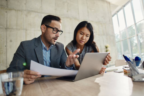 istock Business colleagues working on laptop and paperwork in the office. 2148666474