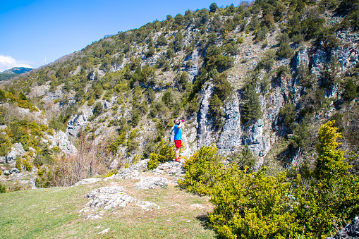 Young man runs on mountain ridge