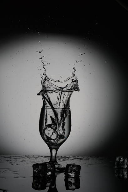 Ice Rock splash in the glass at the photo studio in the black and white background