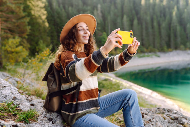 istock Woman using her phone for video call on mountain. 2148669375