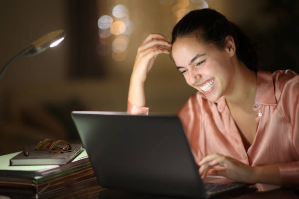 istock Tele worker in the night laughing checking laptop 2148670449