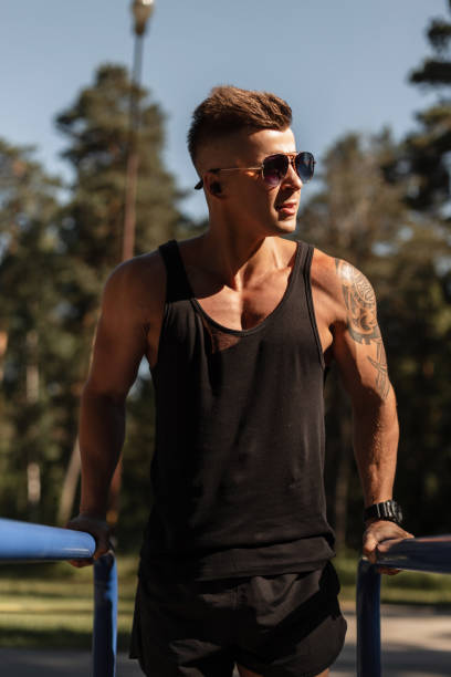 istock Cool athletic handsome guy with a haircut and sunglasses doing exercise and training workout outdoors 2148670859