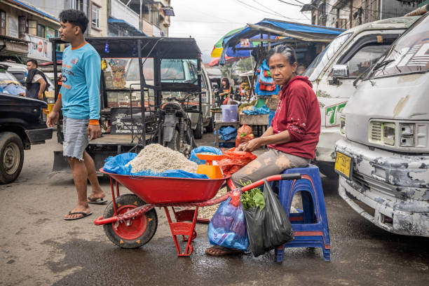 Berastagi, North Sumatra, Indonesia - January 27th 2024:  Woman selling rice from a wheelbarrow at a market stall outside the famous food market