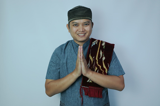 Moslem Asian man smiling when doing greeting pose