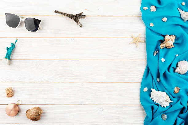 istock Seashells, sunglasses, compass souvenirs blue fabric and starfish on white planks vacation planning background flat lay with copy-space 2148671927