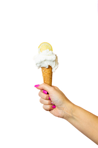 Lemon Ice cream cone with female hand on white background