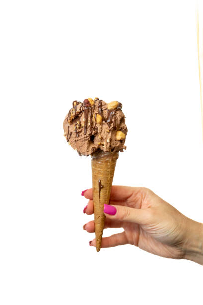 istock Hazelnut and chocolate Ice cream cone with female hand on white background 2148672405