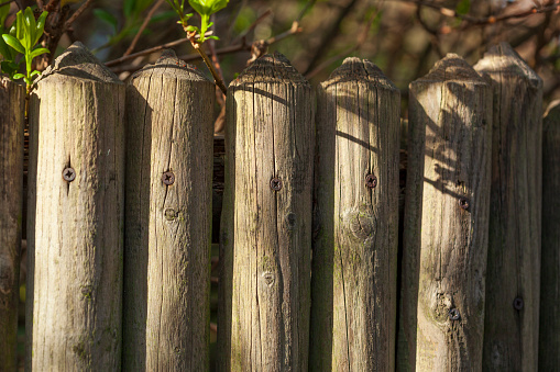 Wooden fence darkened over time, with hand hole.