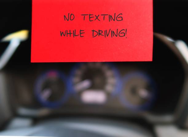 istock Red stick note with text written  NO TEXTING WHILE DRIVING  on the car steering wheel , to remind driver to have safety awareness , stop using mobile cellphone on the road 2148673229