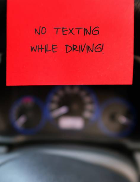 istock Red stick note with text written  NO TEXTING WHILE DRIVING  on the car steering wheel , to remind driver to have safety awareness , stop using mobile cellphone on the road 2148673260