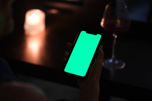 istock hand hold green screen phone in dark bar at night 2148674167