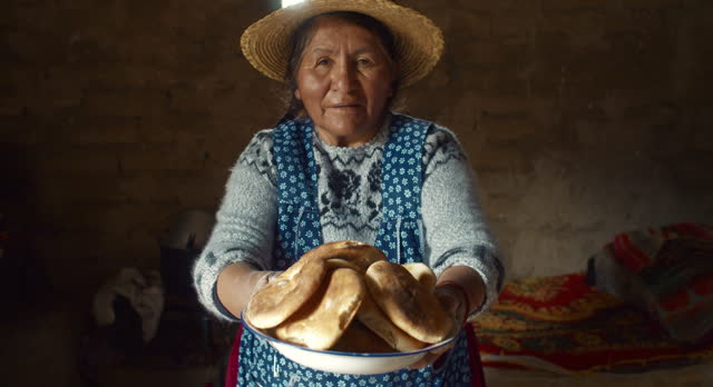 Elderly woman offering Tasty Traditional bread in Bolivia