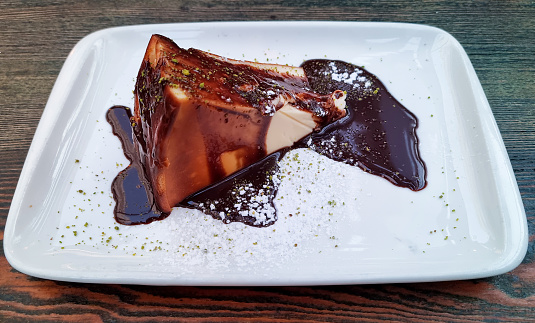 Piece of Chocolate Cake on white plate on wooden background. Homemade chocolate cake.