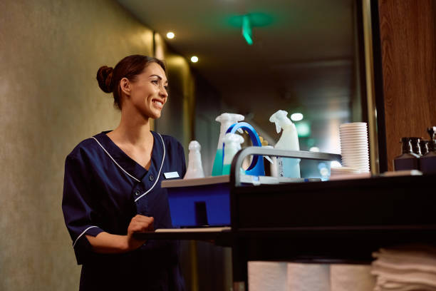 istock Smiling housekeeper pushing chambermaid's trolley. 2148675559