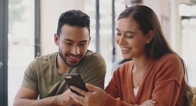 Couple, cafe and happy on date with smartphone to browse or check social media, post and entertainment. Relationship, restaurant and smile on cellphone on internet for networking and funny video.