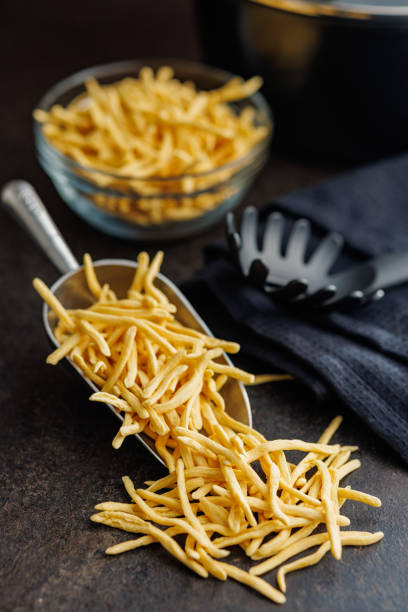 istock Uncooked spaetzle pasta in scoop on a kitchen table. 2148677316