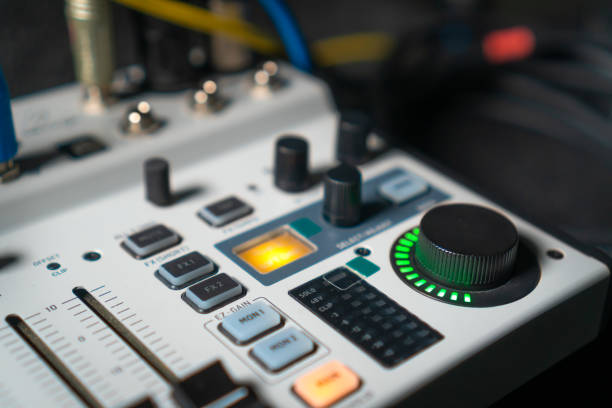 istock Close-up image of hand adjusting mixer knob for volume control during live studio performance. Mixer features multiple knobs and buttons for precise audio mix adjustments. 2148679953