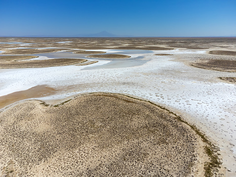 Drone view of dead salt lake Tuz in Turkey. Landscape is like on Moon or Mars, everything dried covered with salt. Here, edible salt is extracted and processed in factory or factory. Alien landscape.