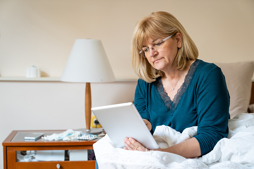 Woman Resting in Bed Checking her Pc Tablet