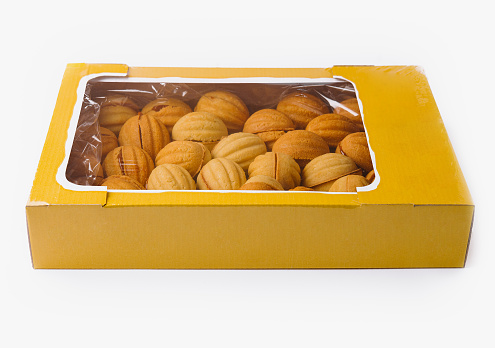 Yellow box full of golden-brown cookies, isolated on a white background with ample space for text