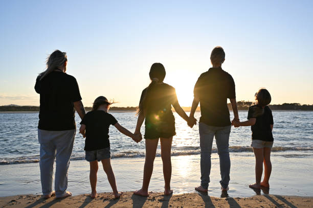 istock Lesbian couple with their daughters holding hands at sunset 2148682787