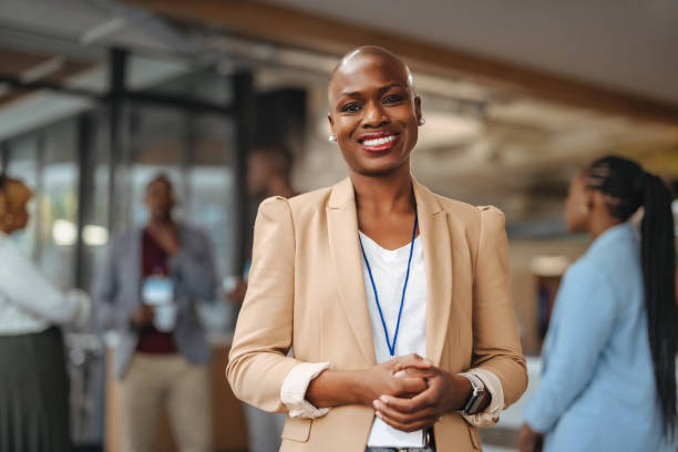 istock Confident professional woman smiling in office environment with colleagues in background 2148683039