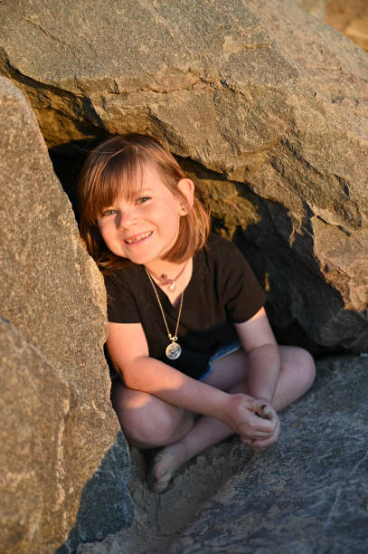 istock Little girl hiding under a rock smiling 2148683065