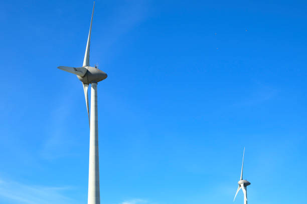 Wind turbines producing sustainable renewable energy in a wind park in Flevoland, The Netherlands, during springtime.