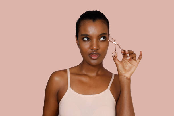 istock Stunning African American Woman Using Eyelashes Curler. Beauty, make-up concept 2148683231