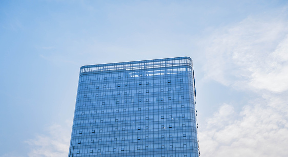 Low angle view of skyscraper with glass window and clear blue sky background for business and finance concept
