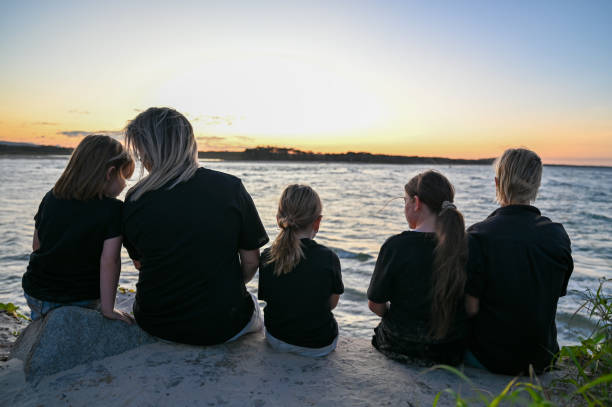 istock A lesbian couple with their kids are watching the sunset.