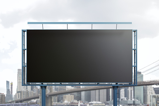 Blank black horizontal billboard on skyline background, front view. Mock up, advertising concept