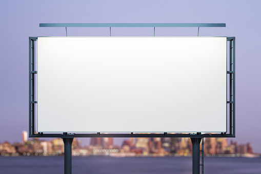 Blank white horizontal billboard on cityscape background at night, front view. Mockup, advertising concept