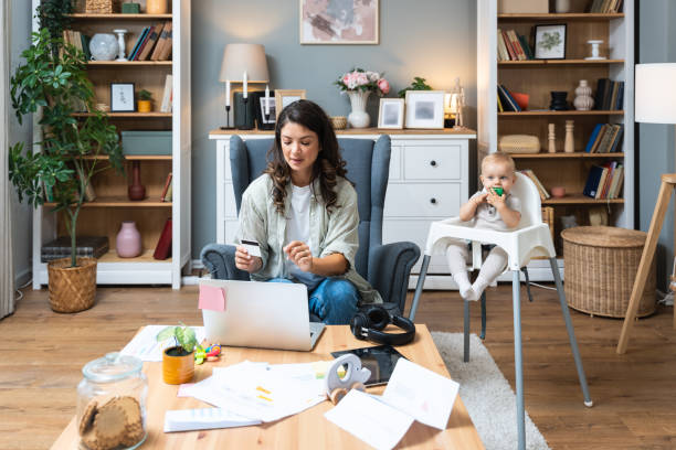 istock Online payments. Happy young mom with kid son or daughter using laptop computer and credit card, making internet purchases with adorable toddler child. Single mother online shopping for baby 2148685319