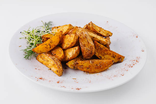 Spicy roasted potato wedges on white plate
