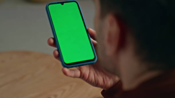 istock Freelancer hands holding greenscreen smartphone at home closeup. Man reading 2148686070