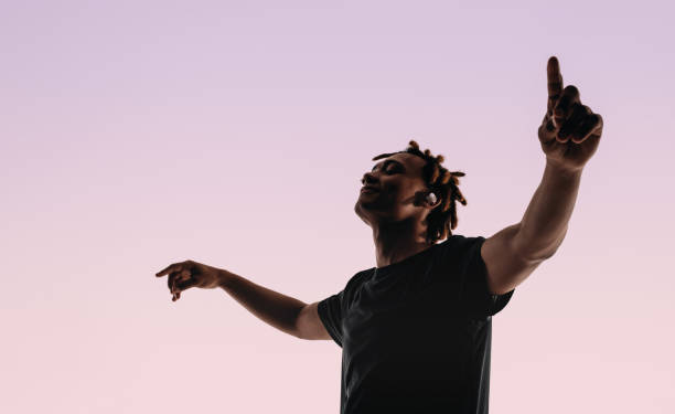 istock Energetic man dancing to music with eyes closed in studio silhouette 2148686071