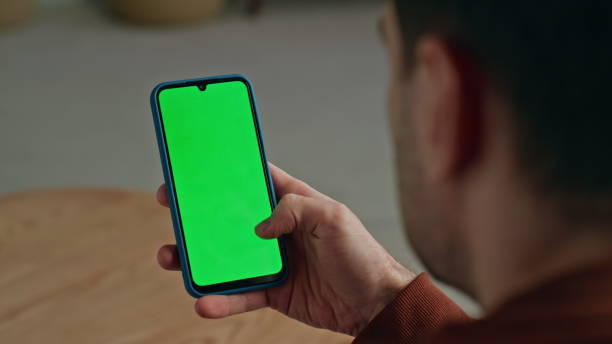 istock User scrolling chromakey smartphone at cabinet closeup. Man hand holding device 2148686606