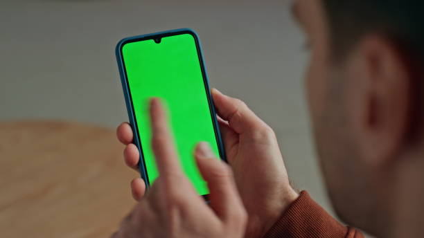 istock Closeup finger touching green screen device. Man hand scrolling chromakey gadget 2148687509