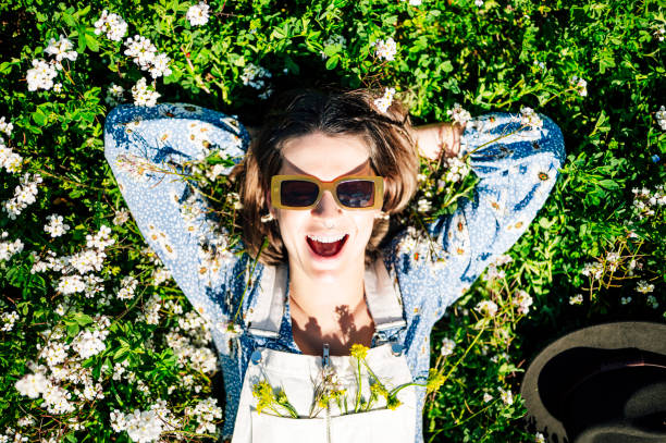 istock Woman lying and smiling in flower field 2148687744