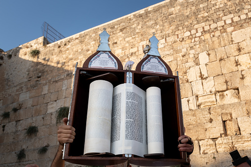 A sefardi Torah scroll is lifted toward the sky during afternoon Jewish prayers on the holiday of Tisha B'Av at the Western Wall in Jerusalem, Israel.
