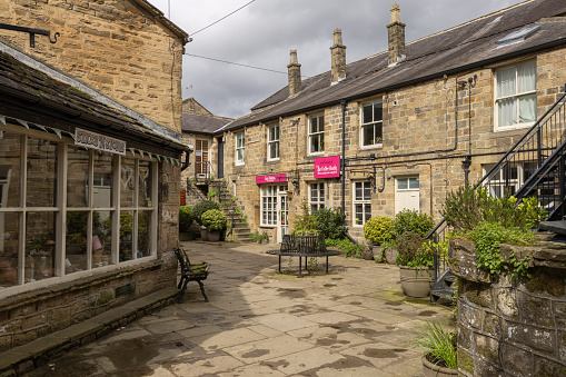 Pateley Bridge, North Yorkshire, England - April 14, 2024: Pateley Bridge shops and cafes in a courtyard, just off the High Street.