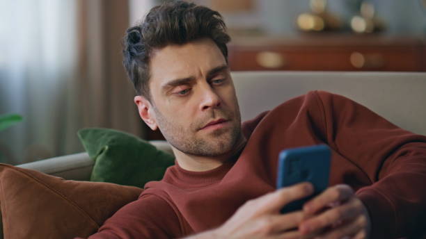 istock Resting man surfing cellphone internet lying at home couch closeup. Guy browsing 2148690868
