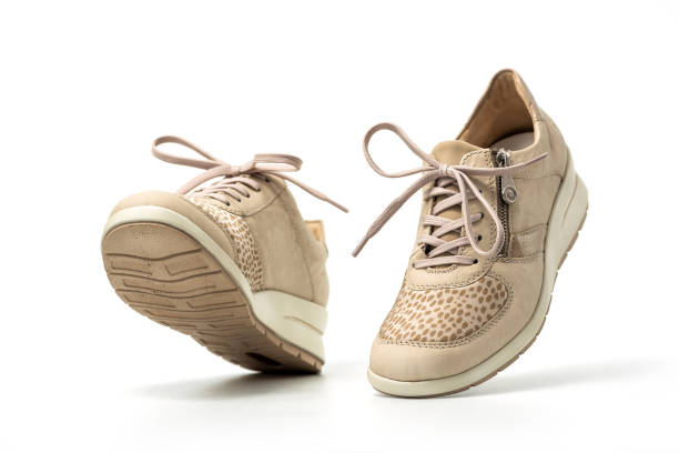 istock Beige female sneakers on white 2148691206