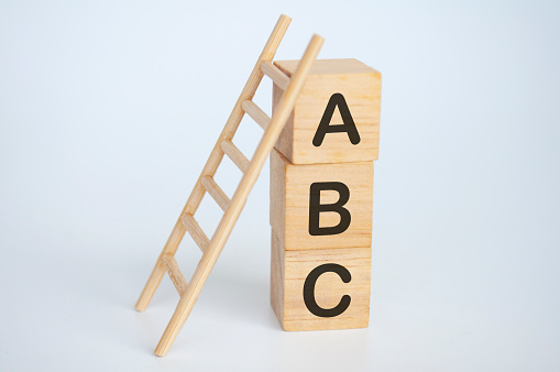 ABC text on wooden cubes with ladder on white background. Learning concept.