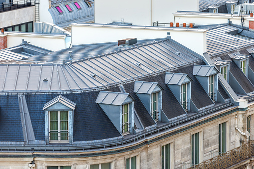 Roofs and windows of residential building, architecture in Paris, France