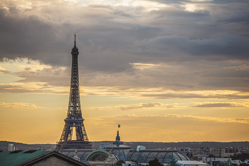 The Eiffel Tower rising above urban skyline in Paris, France under the moody sky at dusk