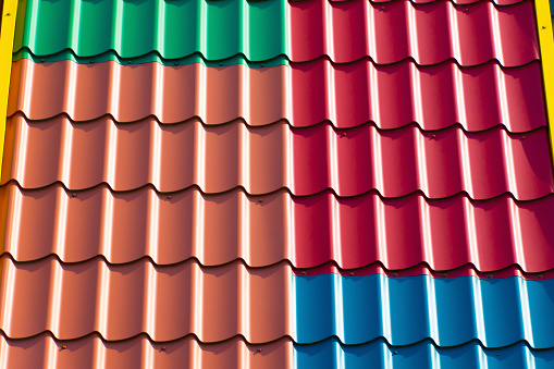 Multi-colored tiles on the roof of a building. Construction Materials.